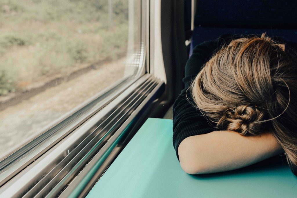 exhausted woman on train needing to learn how to boost energy at work
